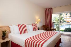 马尔格莱特德玛Luna Club Hotel Yoga & Spa 4Sup的一间卧室设有一张床和一个大窗户