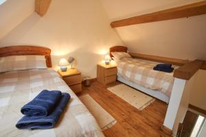 拉科克Barn Cottages at Lacock的配有2张单人床的客房,配有2盏灯