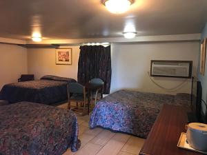 斯蒂尔沃特HWY Express Inn & Suites的酒店客房设有两张床和一张桌子。