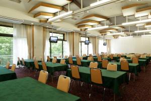 猪苗代町猪苗代町日式旅馆的一间会议室,配有绿色的桌椅