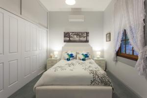 塔姆沃思Rawson's Retreat - Five Bedroom Home - Walk CBD - Includes Breakfast的白色卧室配有一张带蓝色枕头的大床