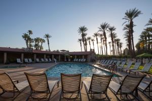 棕榈荒漠Palm Springs Camping Resort Cottage 2的度假村内带椅子和棕榈树的游泳池