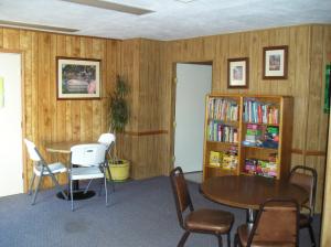 NicolausLake Minden Camping Resort Cottage 2的配有桌椅和书架的房间