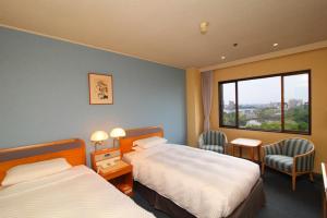 佐贺市佐贺新大谷酒店的酒店客房设有两张床和窗户。