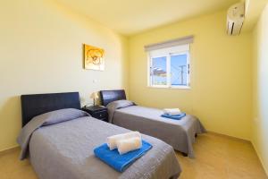 卡拉索斯Athoniki Villas的客房设有两张床和窗户。
