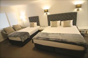 巴特曼斯贝码头酒店的酒店客房,配有两张床和椅子