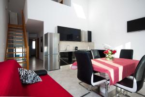 米欧纳Apartment Milna的厨房以及带红色桌椅的用餐室。