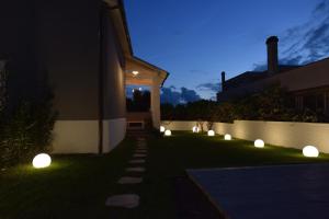 罗马Villa Catona Trigoria的夜晚在草地上点亮的花园