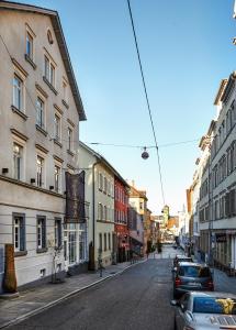 斯图加特德曹贝尔勒凌酒店的一条空荡荡的城市街道,有建筑和汽车停放