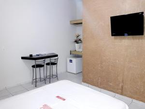 瓦拉达里斯州长市普拉纳尔托2号酒店的一间设有桌子的房间和墙上的电视