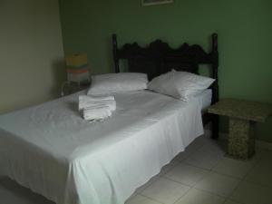 亚卡拉伊比Pousada Dom Diego的一间卧室配有带白色床单和枕头的床。