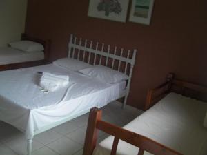 亚卡拉伊比Pousada Dom Diego的一间卧室配有两张带白色床单的床