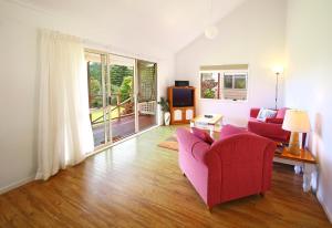 彭特派因Poinciana Cottages的客厅配有红色沙发和电视