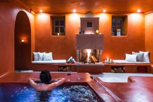 阿诺佩蒂纳Primoula Country Hotel & Spa的坐在浴缸里的带壁炉的女人