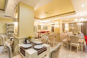 阳光海滩Rena Hotel - All Inclusive的一间设有白色桌椅的用餐室