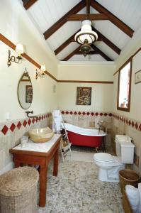 温沃德赛德House On The Path的浴室配有红色浴缸、卫生间和水槽。