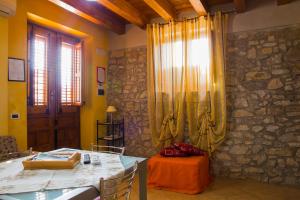 CaccamoCasa Vacanze Caccamo Santa Lucia的一间设有桌子和石墙的用餐室