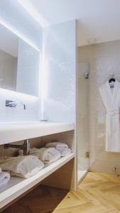 贝济耶Hôtel le XIX的浴室配有盥洗盆、镜子和毛巾