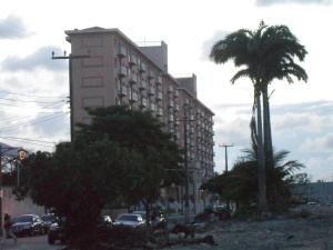 福塔莱萨Apartamentos Vila de Iracema的一条棕榈树街道上高大的建筑