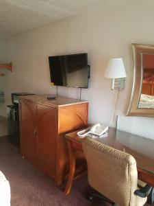 凯斯I-26大师汽车旅馆的酒店客房配有书桌、电视和椅子