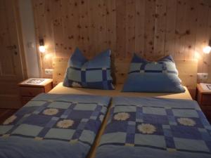 皮恩山口附近施皮塔尔丹巴赫生态休养农家乐的一间卧室配有两张带蓝白色枕头的床