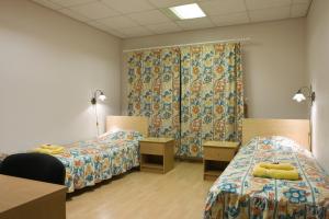 凯尔德拉Posti Hostel的带两张床和窗帘的房间