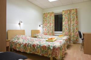 凯尔德拉Posti Hostel的一间医院间,设有两张床和窗户