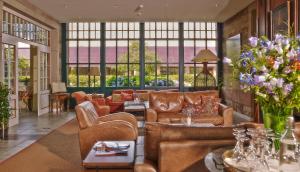 ÜberherrnDer Linslerhof - Hotel, Restaurant, Events & Natur的客厅配有皮革家具和大窗户