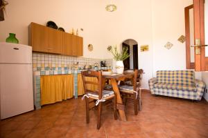 斯克佩罗Villa Chiara的厨房配有桌椅和冰箱。