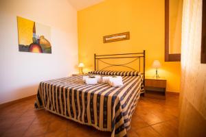 斯克佩罗Villa Chiara的一间卧室配有一张带条纹床罩的床