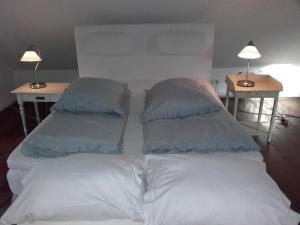 Noord-SleenDe Oude Smederij的一张白色的床,上面有两个枕头