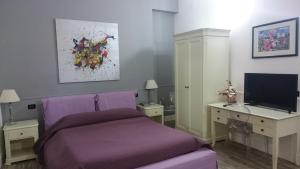 巴格里亚斯卡都托别墅公寓酒店的一间卧室配有一张紫色的床和一台电视机