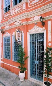 萨尔瓦多Bed & breakfast Villa Carmo的一座橘色的建筑,前面有两棵盆栽的树