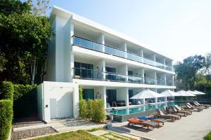 高兰Moonlight Bed & Brunch - SHA Extra Plus的一座设有游泳池、椅子和遮阳伞的酒店