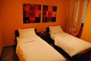 奇列克罗纳格罗萨酒店的橙色墙壁客房的两张床