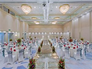 沈阳沈阳JEN酒店-香格里拉集团的一个带白色桌椅的大型宴会厅
