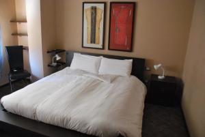 奇列克罗纳格罗萨酒店的卧室内的一张带白色床单和枕头的床