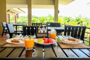 蔻立The Oasis Khaolak Resort - SHA Plus的一张桌子,上面放着两盘食物和橙汁