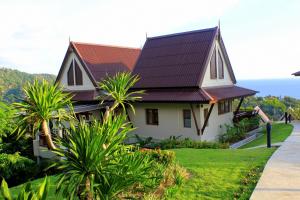 高兰Baan KanTiang See Villas - SHA Extra Plus的绿色草坪上金属屋顶的房子