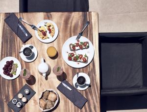 易莫洛林圣托里尼卡沃塔古酒店的一张木桌,上面放着食物盘