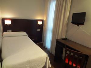 奥伦塞易瑞克斯酒店的一间小卧室,配有一张床和电视