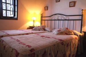 IsoraCasa Rural Faustina的一间卧室设有两张床和窗户。