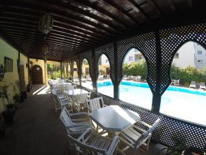 索维拉里亚德扎赫拉酒店的游泳池旁带桌椅的天井