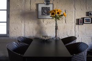 阿尔勒Appartements "La Chambre D'Ami"的一张带向日葵花瓶的餐桌