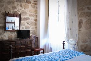 蒙桑图Casa Pires Mateus的一间卧室配有一张床、梳妆台和镜子