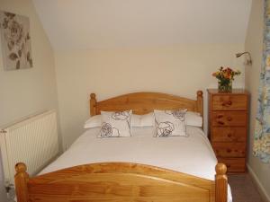 贝德福德Fosbroke Cottage的一间卧室配有一张带两个枕头的木床