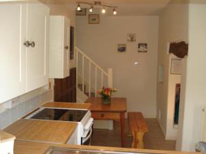 贝德福德Fosbroke Cottage的一间带炉灶和桌子的厨房(位于客房内)
