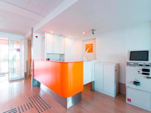 千叶千叶滨野R16岐山酒店的一间位于客房中间的带橙色岛屿的厨房