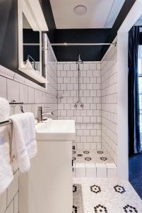悉尼北悉尼酒店 的白色的浴室设有水槽和淋浴。