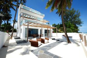 吉汶瓦Amani Home - Moja Private Beach Suite的棕榈树海滩上的房子